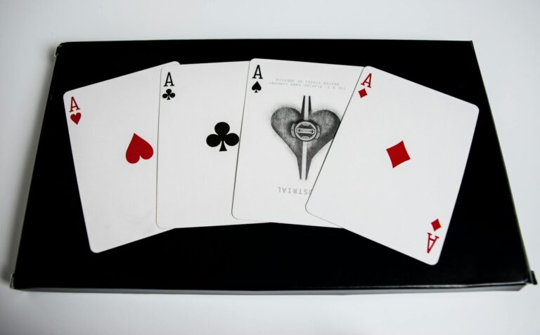 High-quality image of four aces from a deck of playing cards on a black surface.