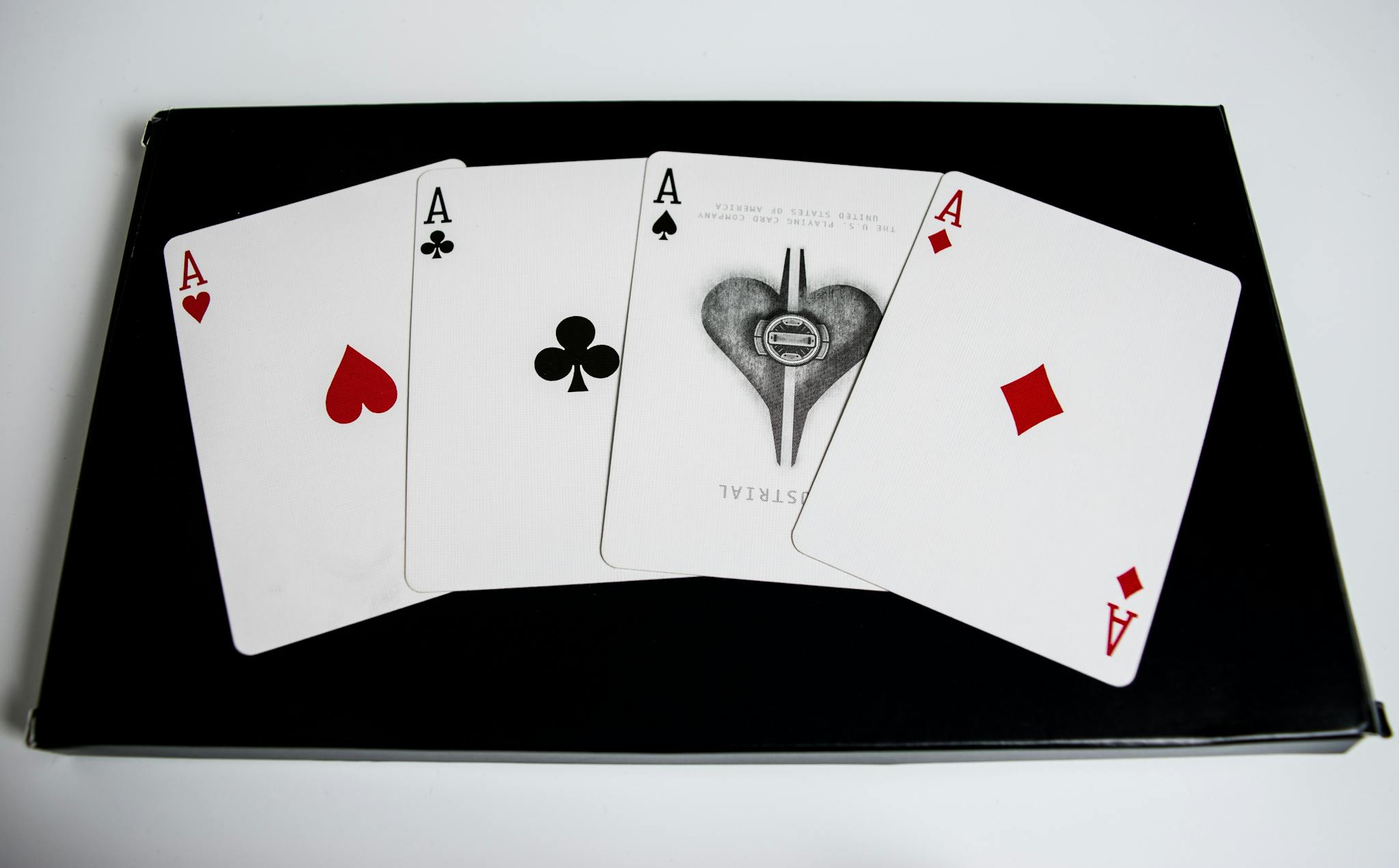 High-quality image of four aces from a deck of playing cards on a black surface.