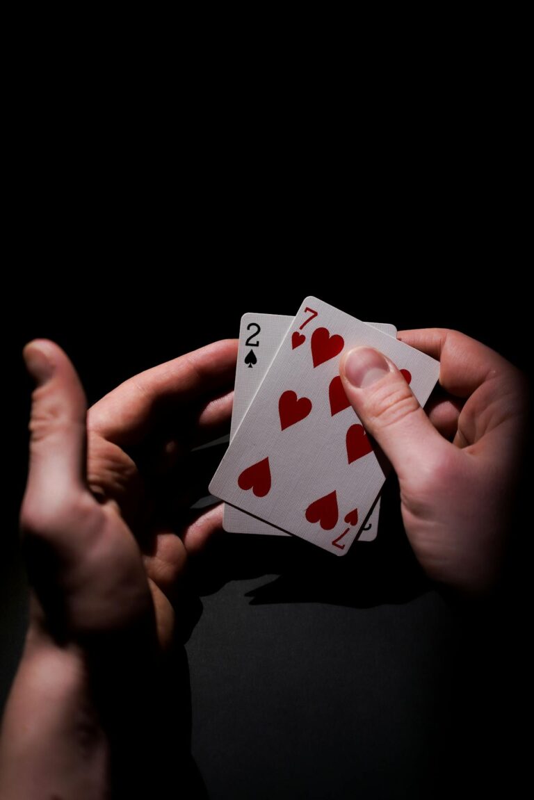 Intense close-up of poker cards in a player's hand, highlighting the suspense of gambling.